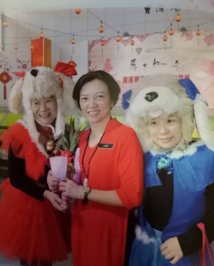 李爱娴（中）在中化三小掌校期间，曾在慈济迎新春活动上，和两名打扮可爱的家长合照。
