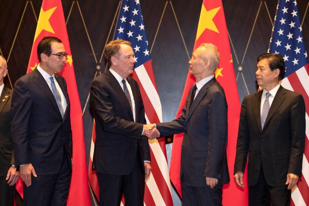 美方的贸易代表莱蒂泽（左2）与中国副总理刘鹤（右2）互相握手，在场的还有美国财长姆努钦（左）与中国商务部长钟山（右）。