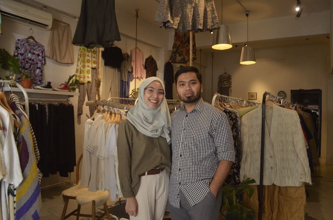 努爱妮（左起）和莫哈末阿尔发共同经营的二手女装精品店“Label Jiqaien”获得不少年轻女性的青睐，两人也身穿自家品牌的服装。