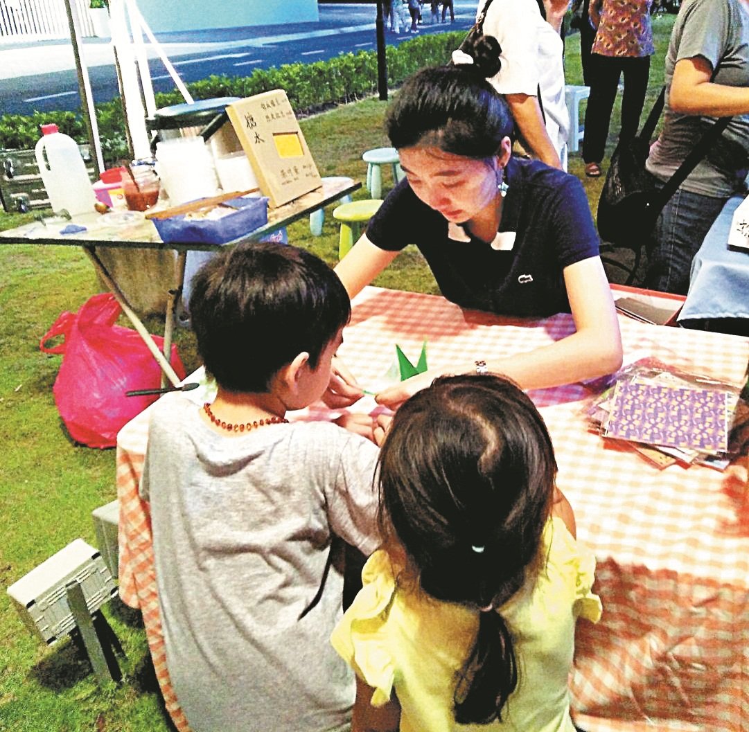 许晓彤细心地教导小孩折纸，除了希望小孩可挖掘折纸的乐趣，从而推广折纸艺术。