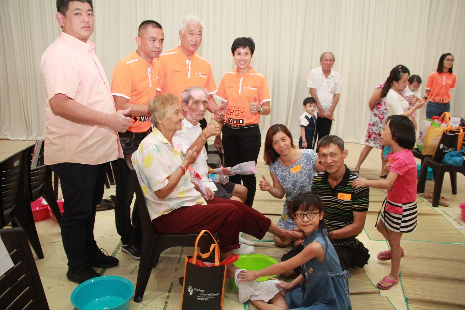 陈治中（站者左起）、杨式丰、彭文宝和凌絉玲与三代同 堂一起参与百人浴足活动的一家人合照。