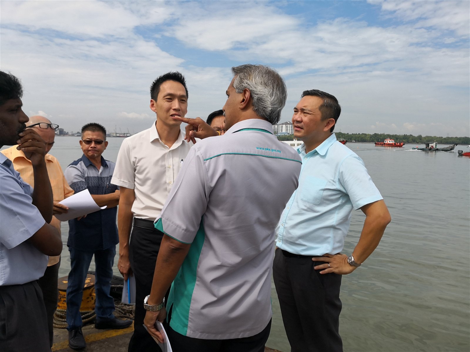 欧阳捍华（左）和黄思汉（右）在巴生南港吉胆码头，聆听苏巴马廉（右2）的汇报。