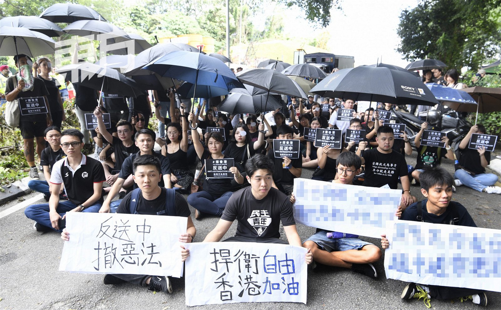 逾50名声援香港“反送中”集会者无法照原定计画游行下，于是原地静坐、撑黑伞给予香港人民精神支持。（摄影：伍信隆）