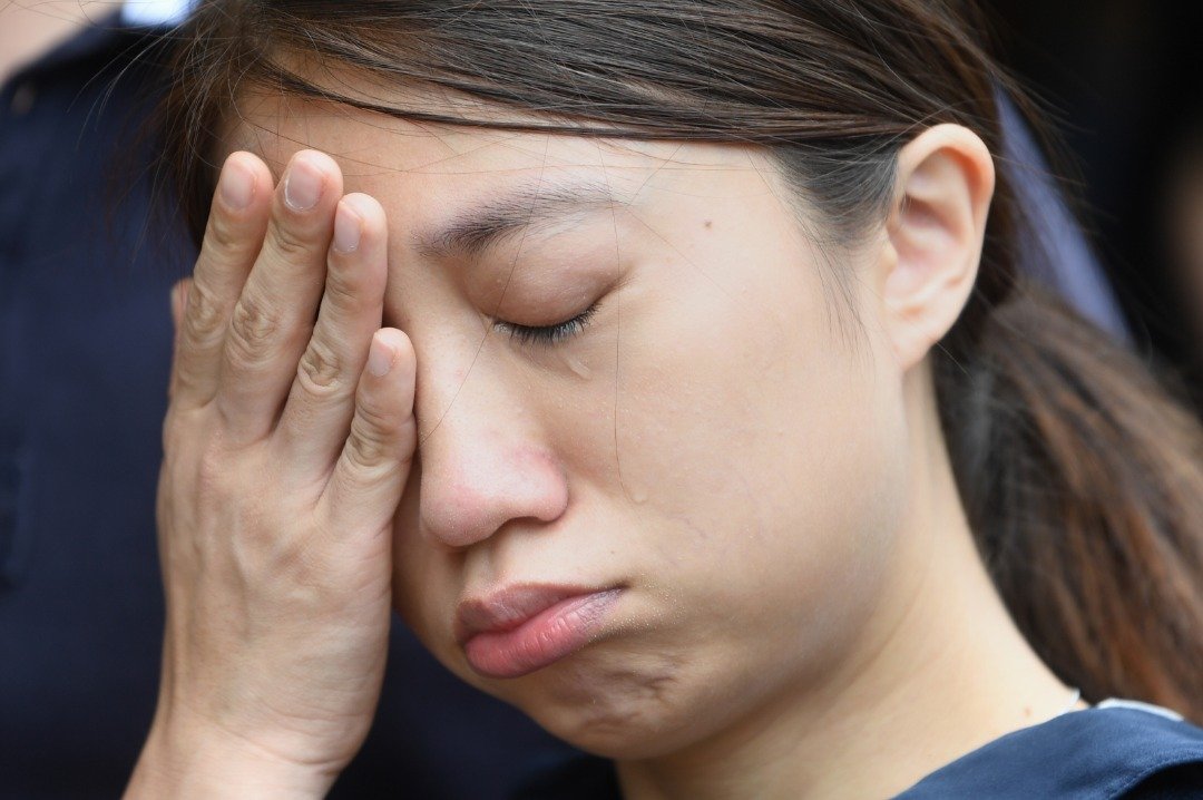 一名在梁凌杰坠楼地点哀悼的女子，不禁悲从中来、掩面流泪。香港特首林郑月娥周六宣布，暂缓修订《逃犯条例》，但是仍然不能平息民怨。