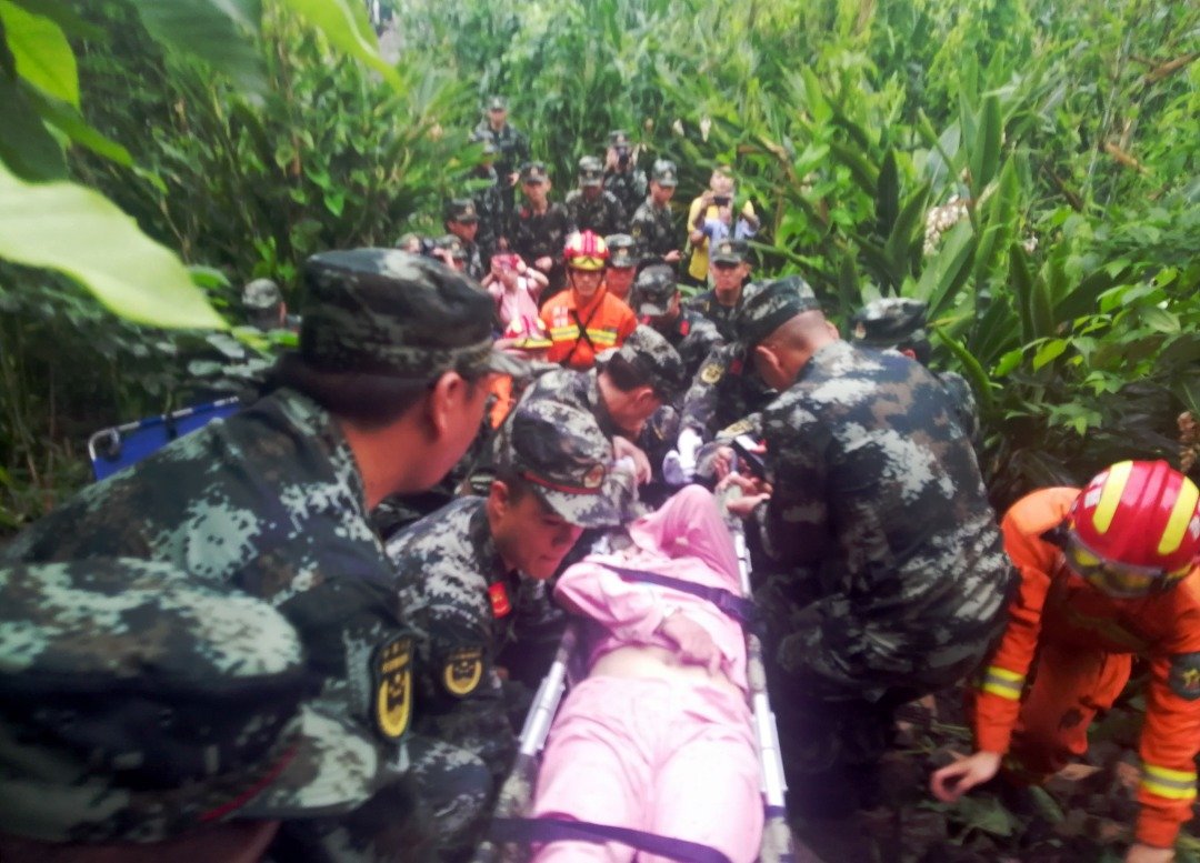 在长宁县双河镇，武警官兵转移救出一名地震伤者。