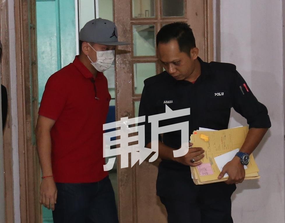 林远志（左）戴上口罩，面控后由庭警押至扣留室，以办理保释手续。（摄影：刘维杰）