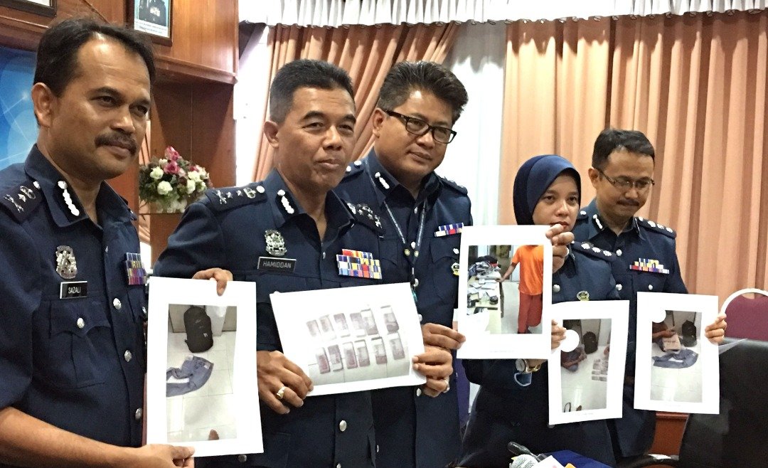 莫哈末哈密丹(左2）展示柔佛州关税局官员，在麻坡所侦破的案件，照片显示印尼籍男子携带大笔未申报的令吉进入我国。