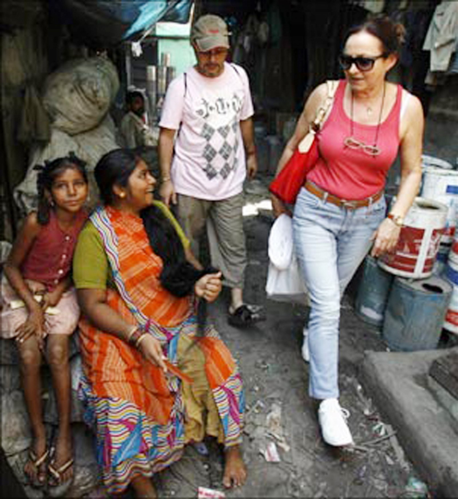 一名西方旅客在达拉维平民窟中行走，经过一名坐在小巷梳头的当地居民。随著著名电影《贫民百万富翁》于2008年上映，逐渐有游客踏足达拉维，为当地的旅游业带来商机。