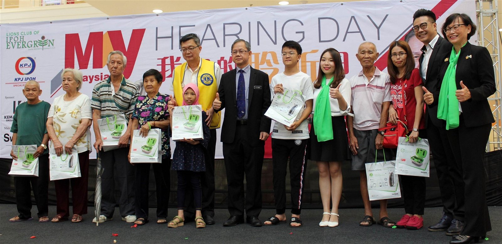 李文材（左6）代表大会移交助听器， 给8位面对听觉障碍的受惠者。