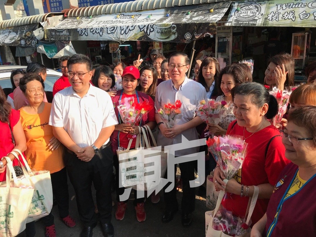 升旗山国会议员黄汉伟（左2）、林冠英（左4）等人于周日早上配合三八妇女节前往亚逸布爹选区派花给当地妇女。（摄影：陈振豪）
