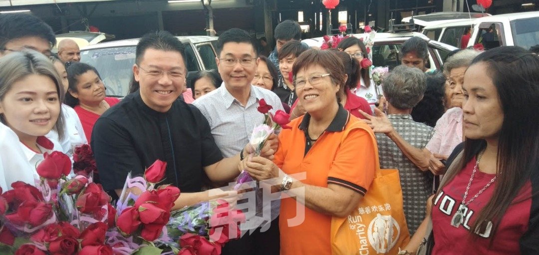 倪可敏（左2）赠送一朵玫瑰花予妇女，令后者乐开怀。左3为郑国霖。