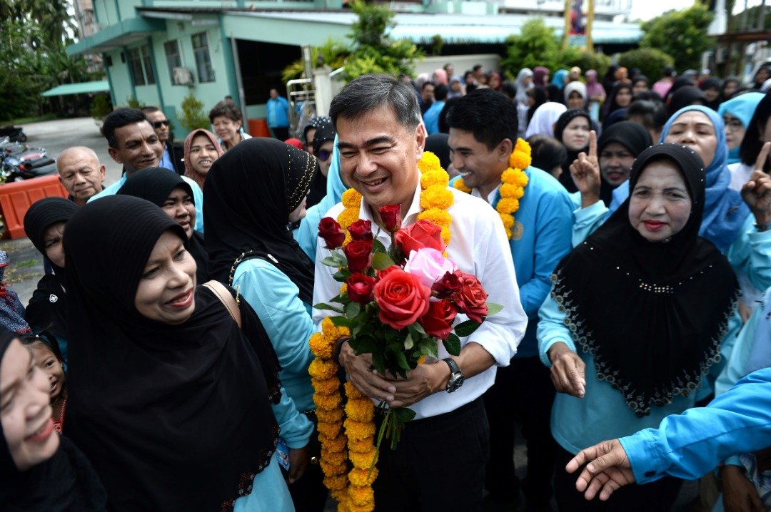 民主党首相候选人阿比昔（中）在陶公府展开竞选活动期间，支持者为他送上花环及鲜花。