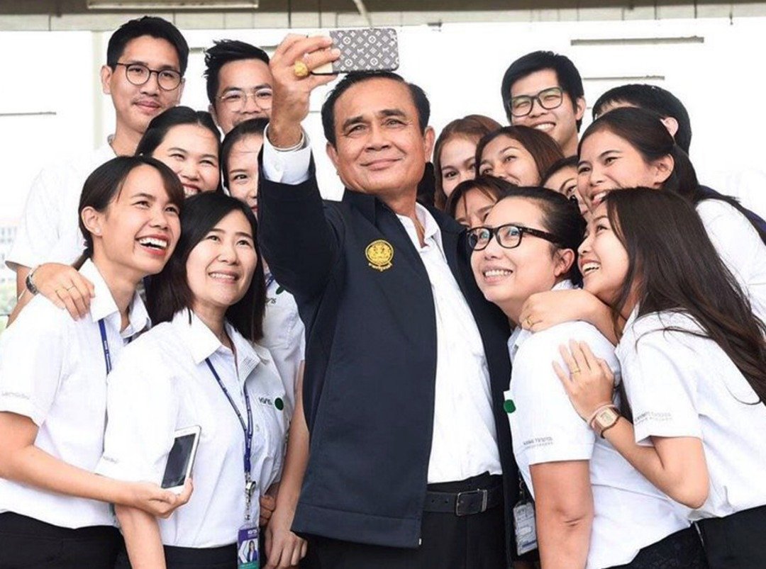 寻求连任的现任首相巴育（中）正拿著手机与年轻的支持者自拍。此次泰国大选新增了740万名“首投族”，而据曼谷大学近日对“首投族”的调查显示，有79%的选民表示会参与投票。