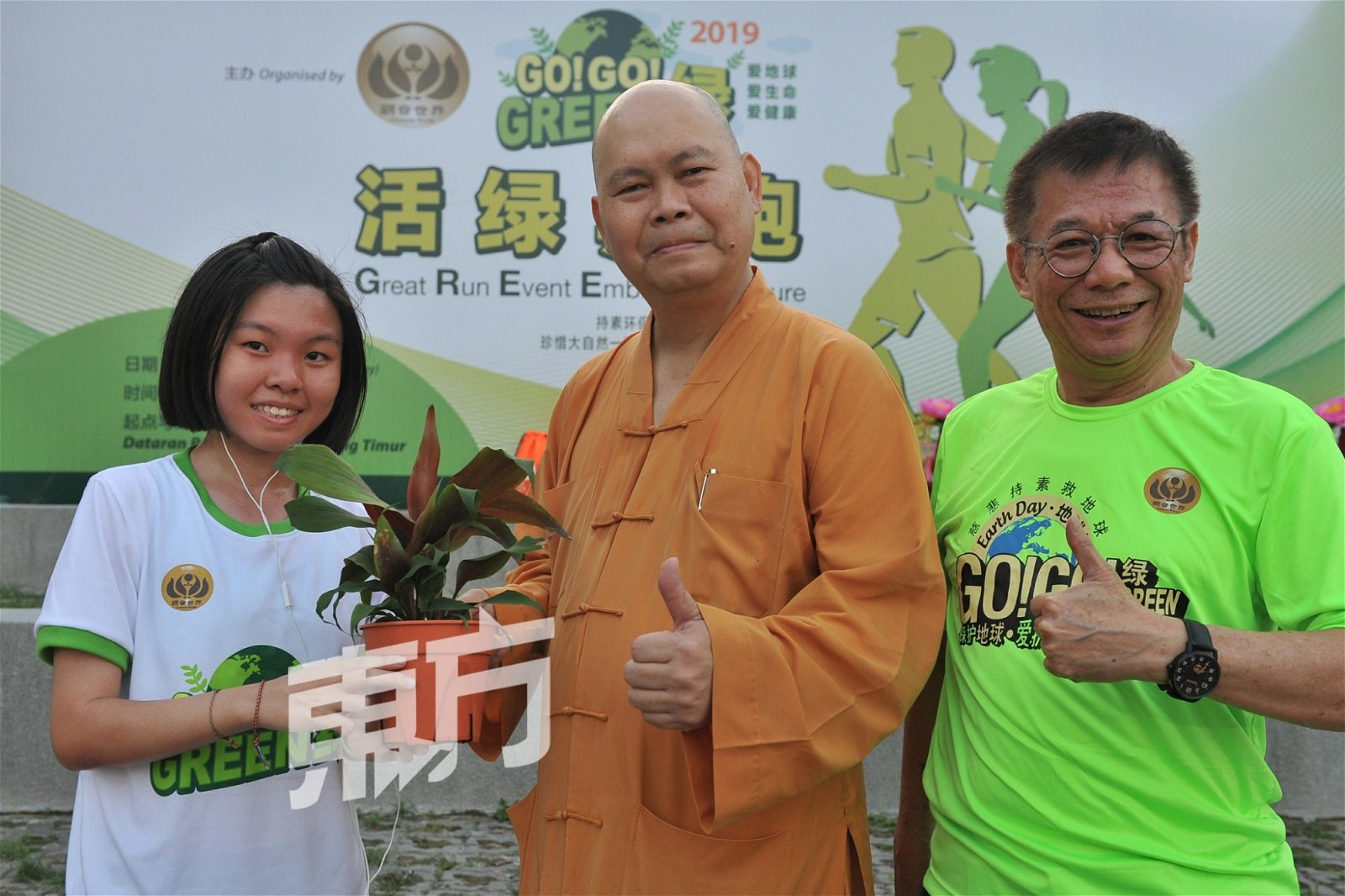 陈俐君（左）从明吉法师（中）手中接过，名为“活绿 生命之礼”的树苗。（摄影：连国强）