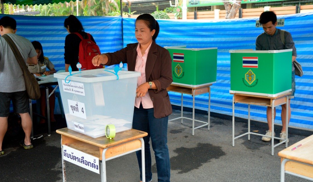超过260万的泰国选民，周日一早就抵达他们选区内的投票站，进行“缺席投票”。这是选民正把选票放入投票箱，一旁亦有选民在选票上，填选心目中的首相人选。