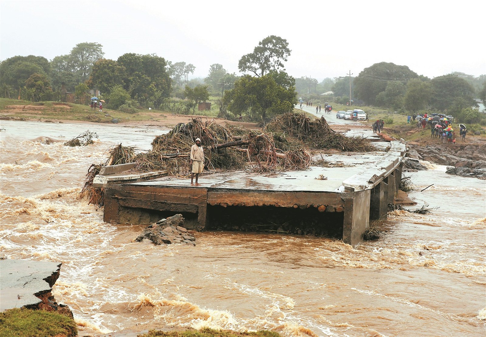 一名男子茫然地站在遭洪水摧毁的断桥上，望著一旁湍急的水流。津巴布韦东部的奇马尼马尼市是此次伊代风灾中的重灾区，当地的建筑、桥梁均被洪水破坏。