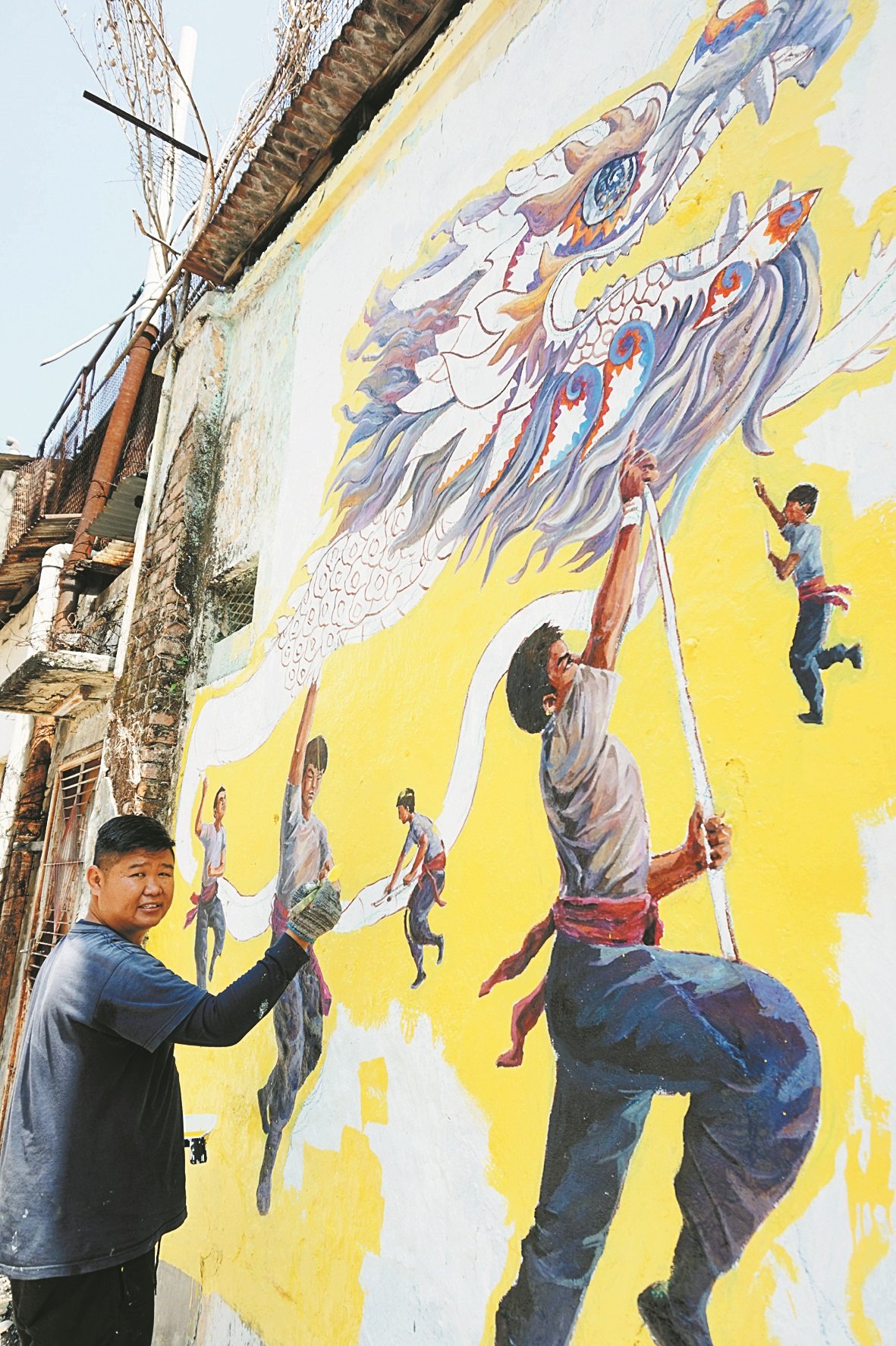 赖伟权为后巷壁画展开重绘及修复工作，为公共艺术献力。