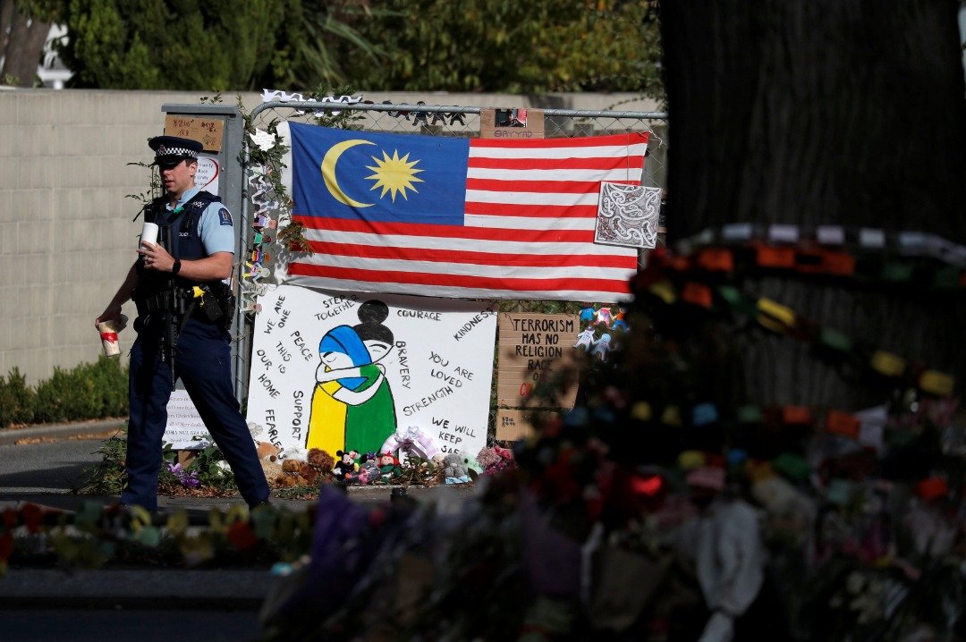 艾努尔清真寺外的围栏上，挂了一幅马来西亚国旗，还有各种自制的海报和悼念纸板，上面写著“坚强”、“基督城愿你平安”等内容。围栏底下则放满了花束和玩偶，是民众过去一周为悼念恐袭受害者所留下的礼物。