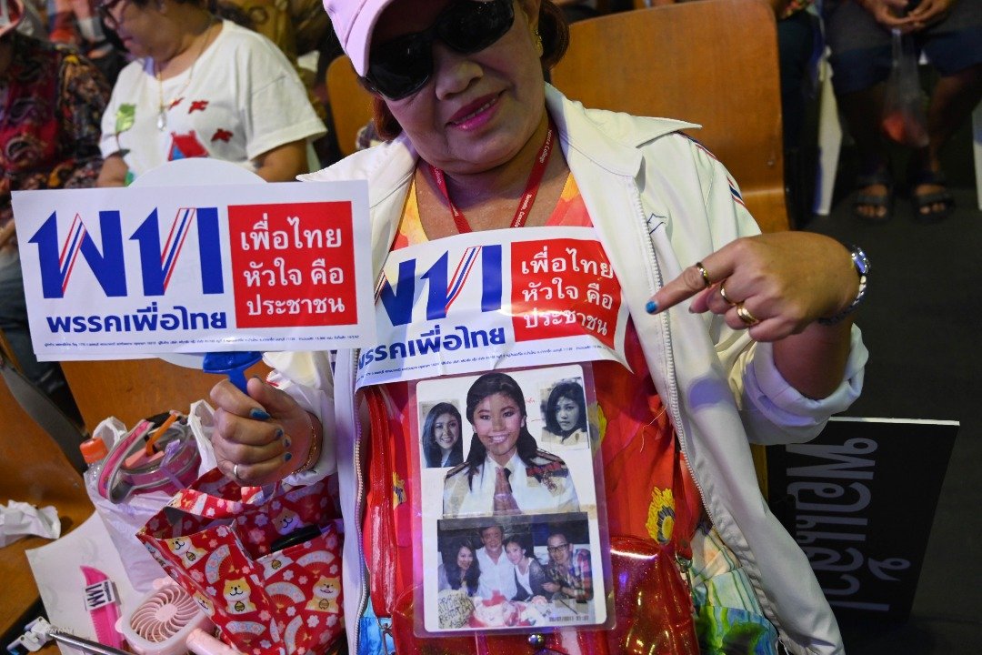 为泰党是泰国最大反对党，亦是这次的大选焦点。尽管前首相塔辛及其胞妹英叻已流亡海外，但影响力依然垄罩著泰国政局。这是为泰党一名支持者在胸前挂上塔辛和英叻的照片，以示对他们的怀念与爱戴。