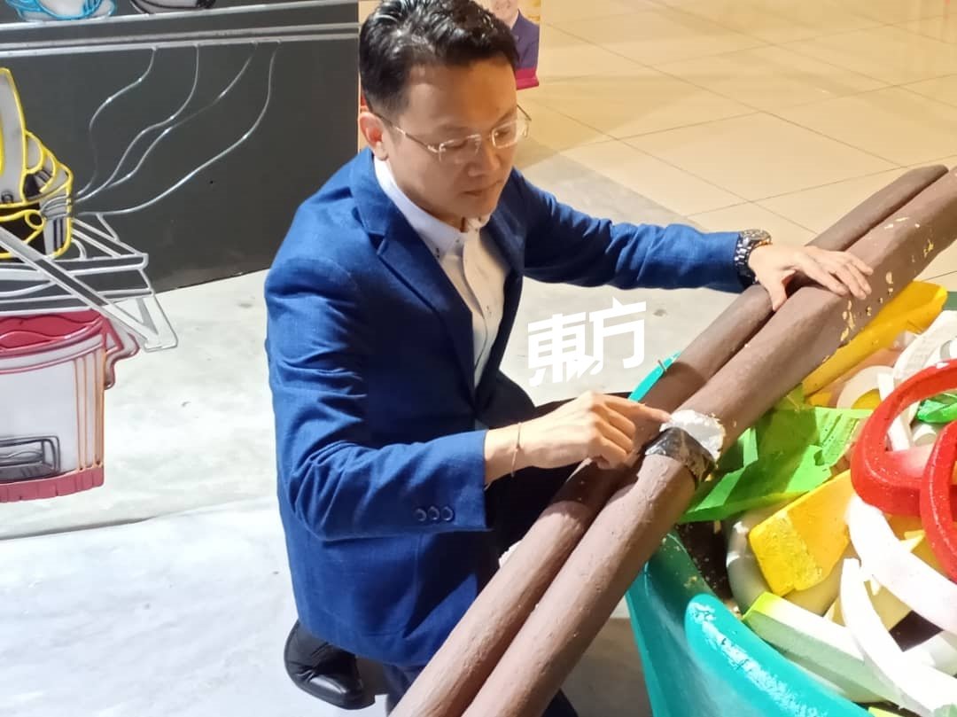 杨顺兴无奈地看著“叻沙”上断裂的筷子，希望民众能爱护这些展览品，保护艺术家们的心血。（摄影：叶全凯）
