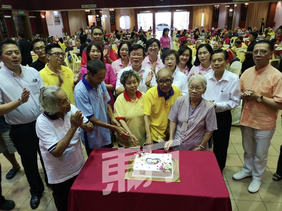 曹观友（后排左4起）和夫人陈莲枝及出席嘉宾，与各个安老院代表一同切蛋糕庆祝双亲节。