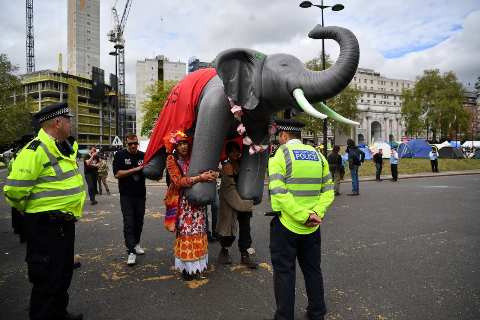 气候变化运动人士上个月24日在英国伦敦大理石拱门，参与反抗灭绝组织的环境示威营，并展示充气大象工具，呼吁当局以政治变革因应气候变迁。（法新社）