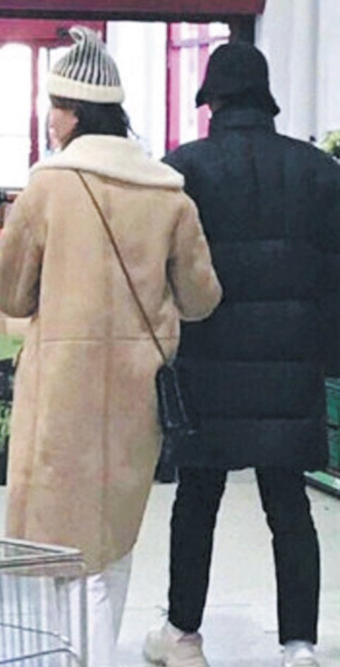 杨洋和乔欣疑似牵手逛街， 杨洋有相似黑色外套， 乔欣则有相同驼色外套。