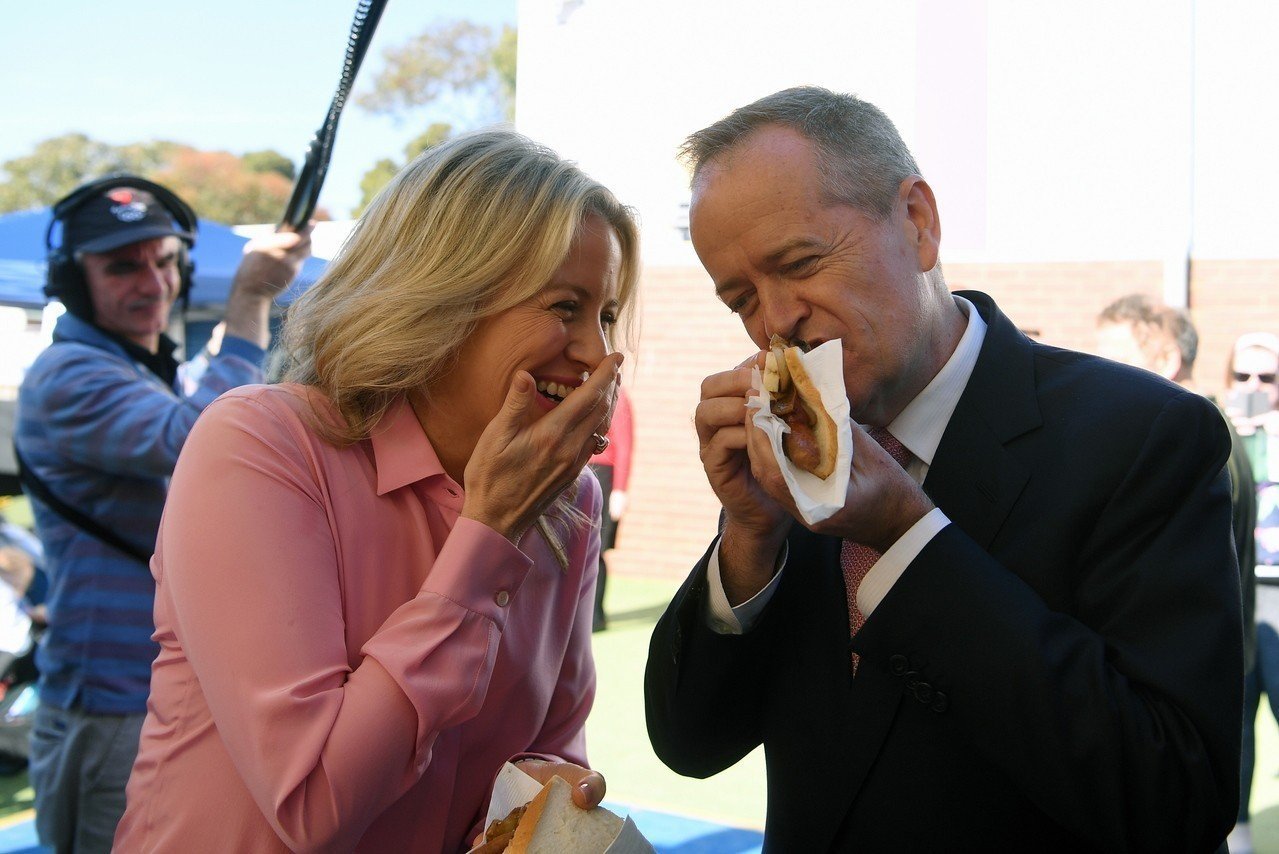 澳洲工党党魁薛顿（右）和妻子克劳伊在18日投票当天大吃“民主香肠”。