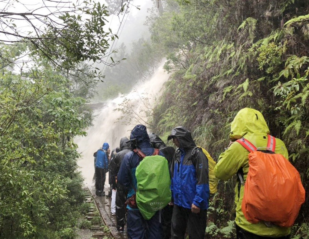 暴雨所引发的洪水，阻挡了屋久岛町登山客的去路，众人被迫滞留在一旁。