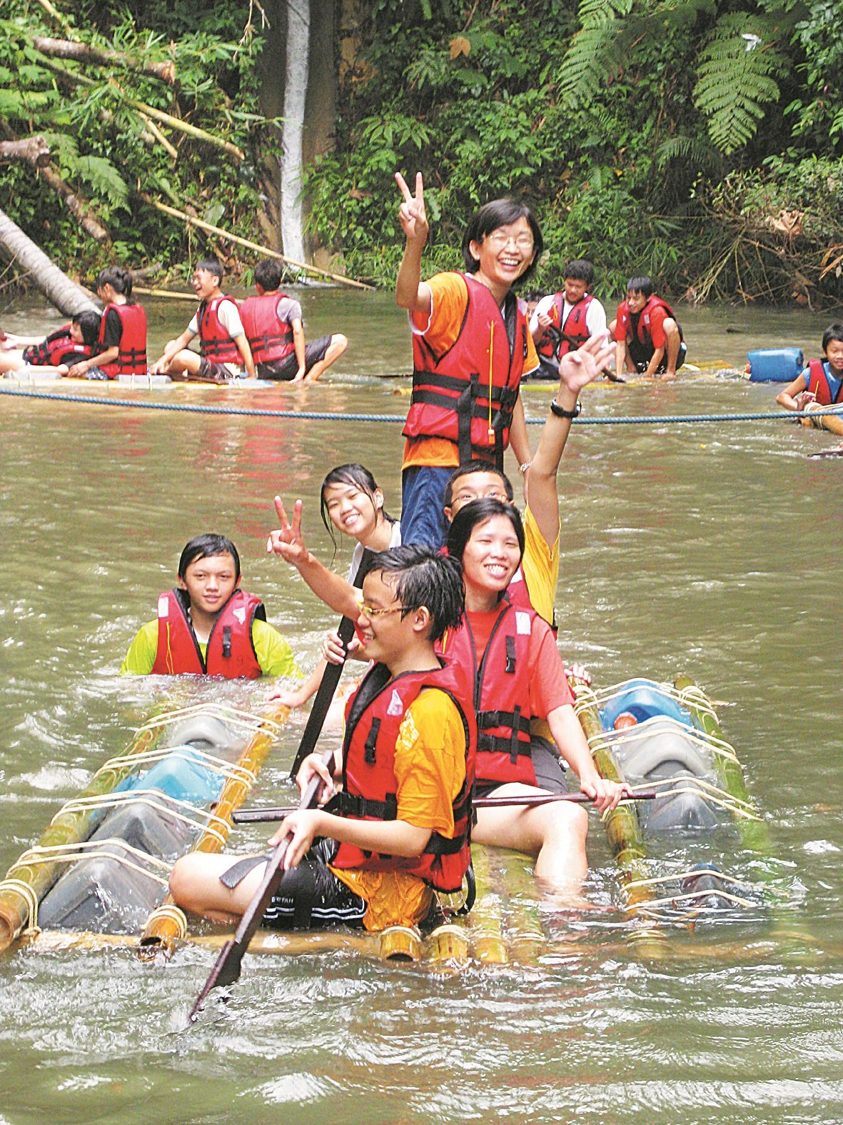 吕秀兰（坐者左2)和学生们乘著自制的木筏，考验耐力和勇气。