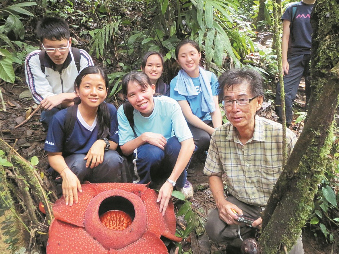 吕秀兰（前左3起）、本地山岳专家甘苍林与学生们在金马崙观赏稀有品种的大王花。