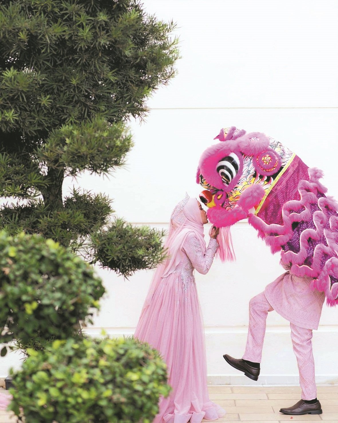 新郎头戴华人传统舞狮与巫裔新娘甜蜜互动，巧妙融入了我国多元文化。