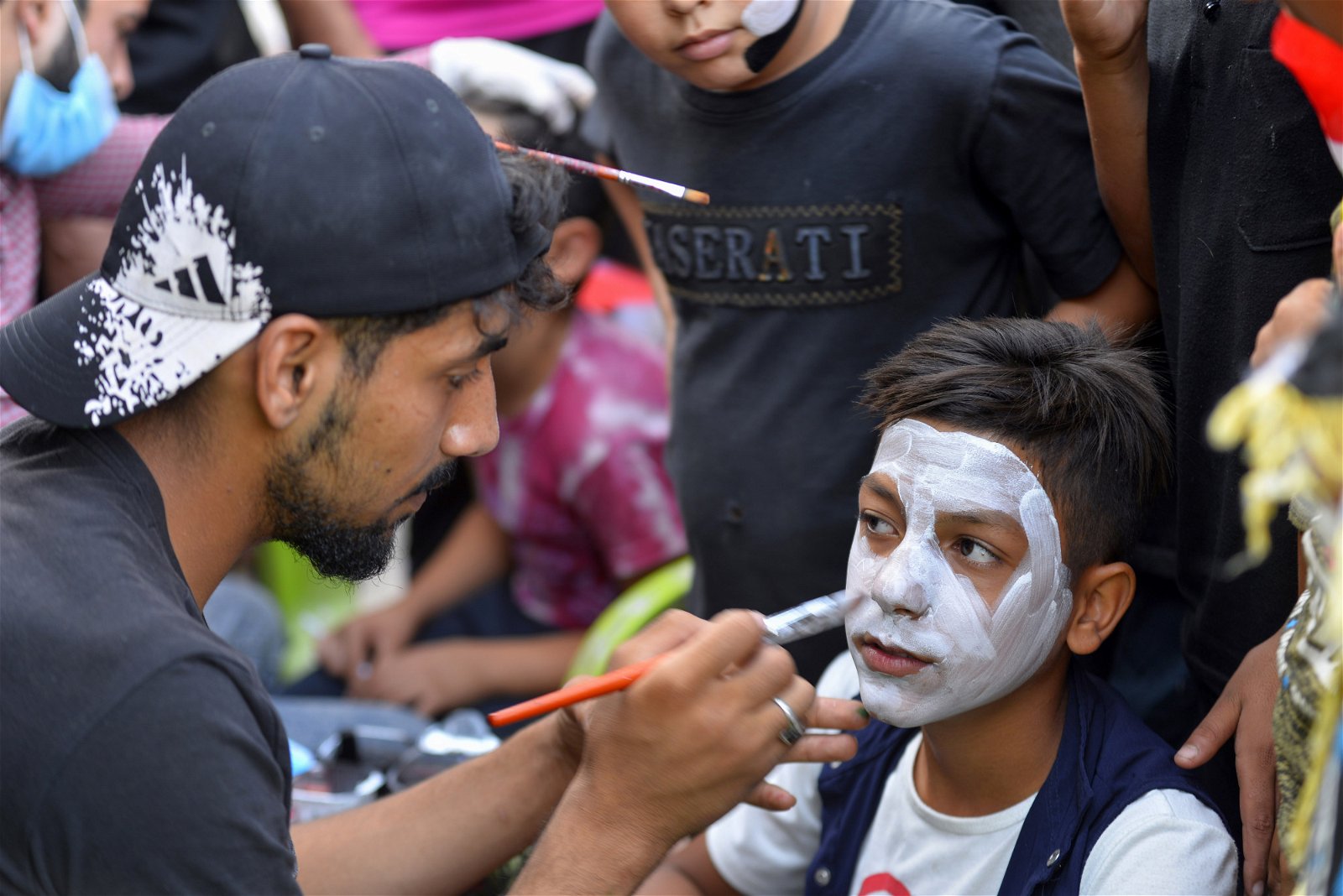 为抗议政府腐败、服务不力及高失业率等，伊拉克各大城市近日爆发新一轮示威，酿成数十人死亡。周六在什叶派城市纳杰夫，参与示威者正在替一名男童画上小丑脸谱，脸谱下不难看见男童脸上的不满和愤怒。