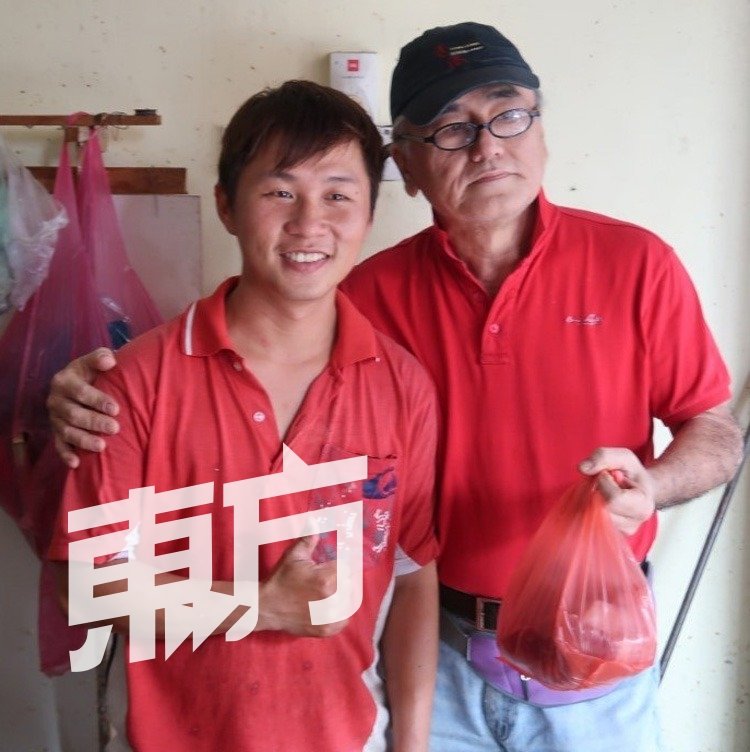 槟城咖哩面“六叔”骆天明（右）与猪肉贩谢坚杰（左）相见欢，互相激励打气为拉曼大学献力。