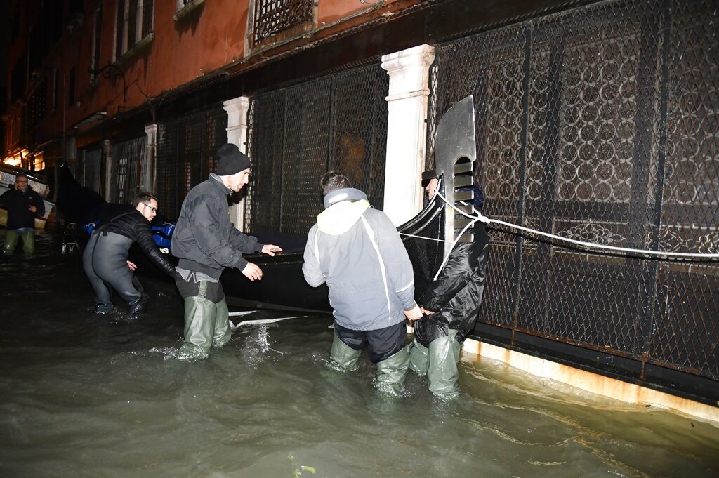 水淹商店，工作人员移走财物。