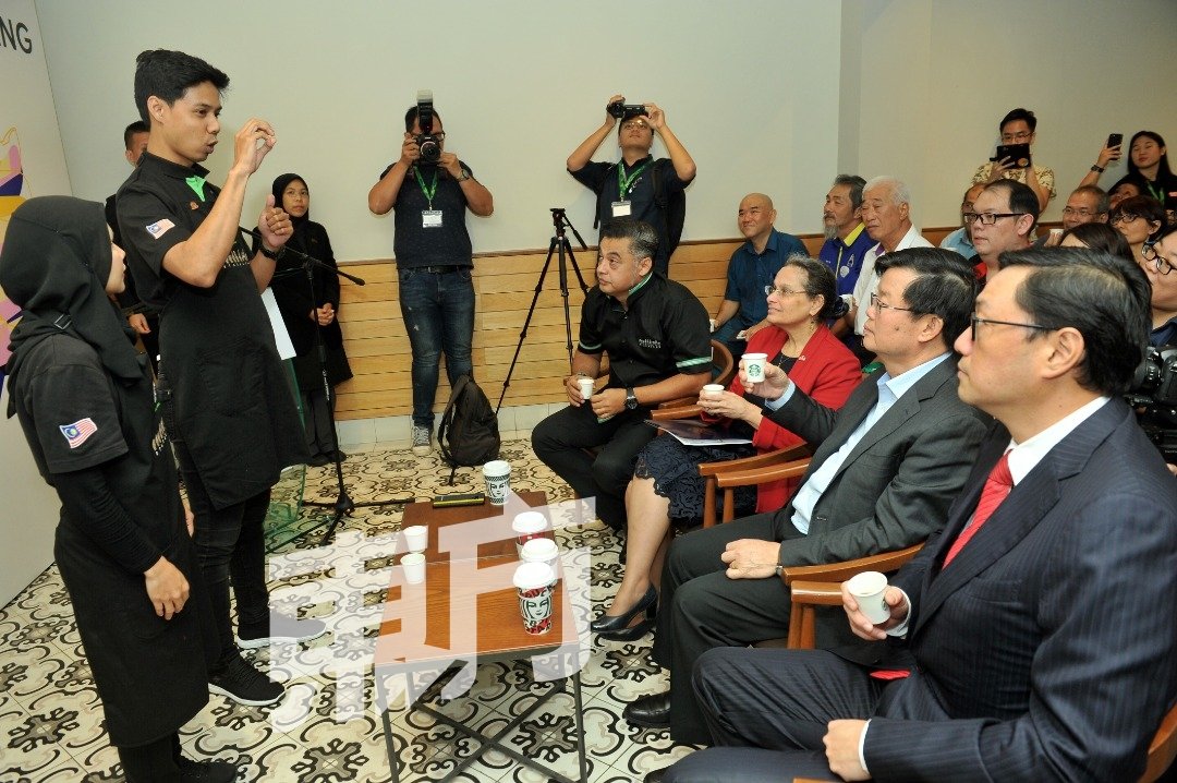手语星巴克聋哑员工正为曹观友（左3）讲解咖啡资讯。（摄影：蔡开国）
