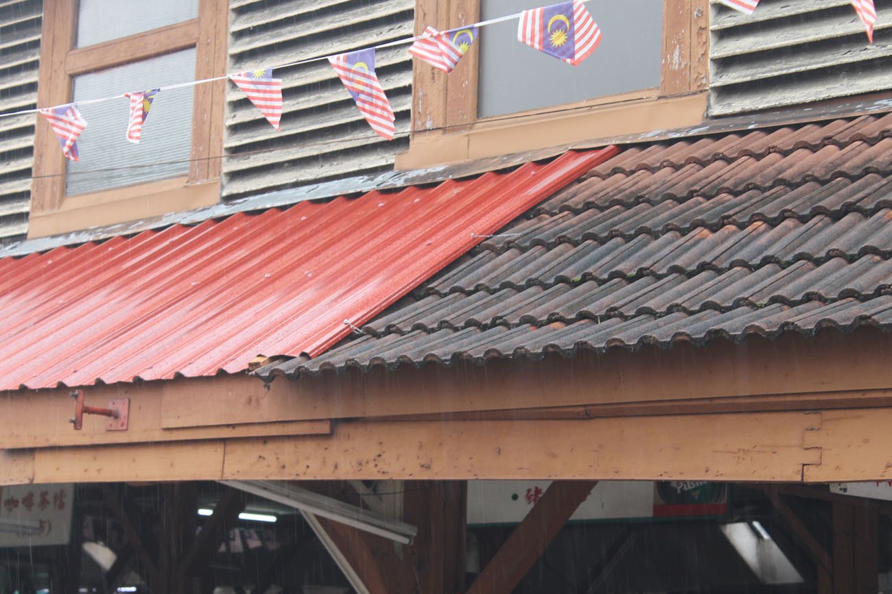 不夜天公市的部份屋顶日前改换成镀锌浪板，与另一边的旧屋瓦形成强烈对比。