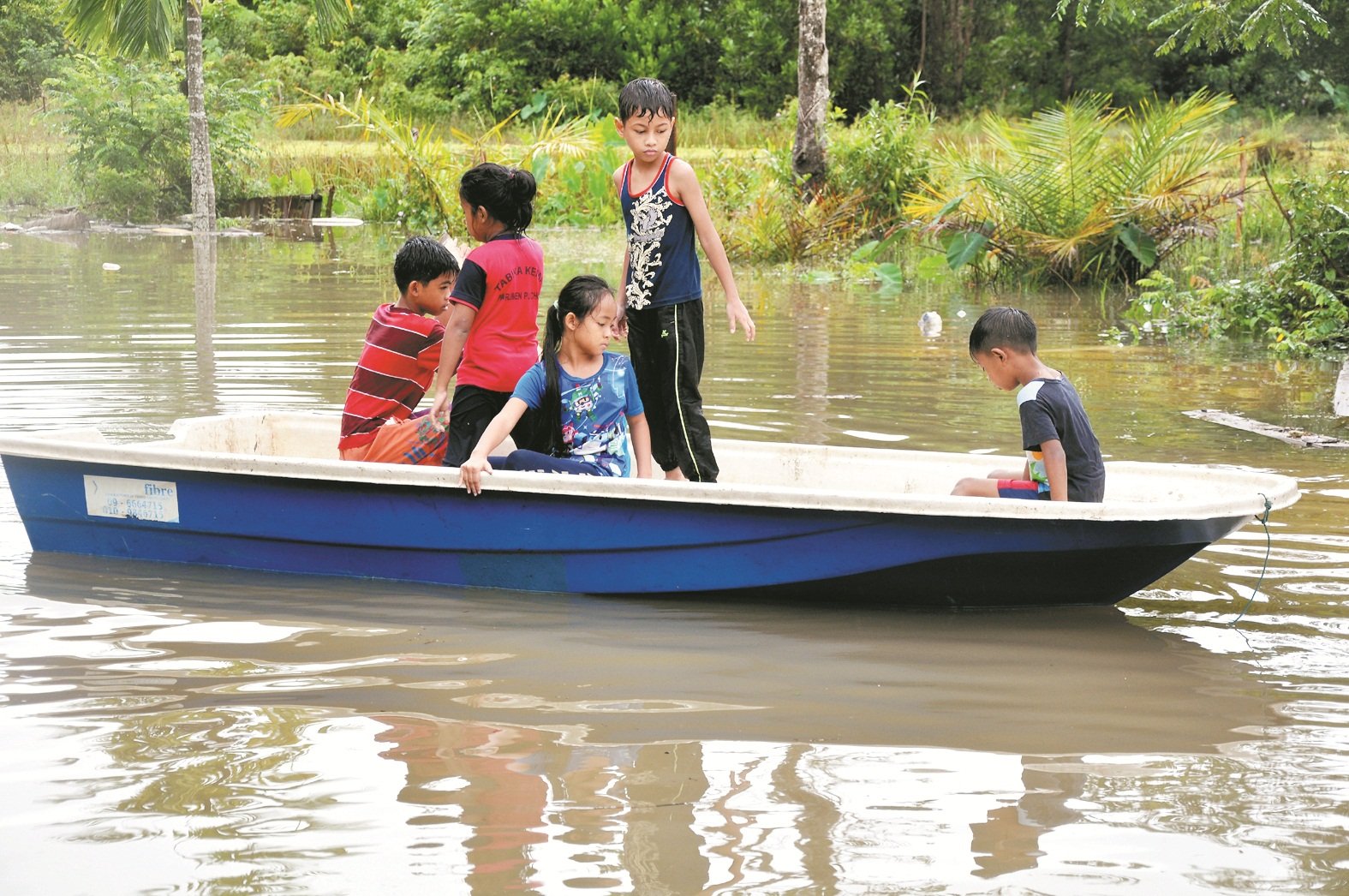 登州勿述的水灾灾情恶化，当地小孩必须乘坐舢板才能外出。