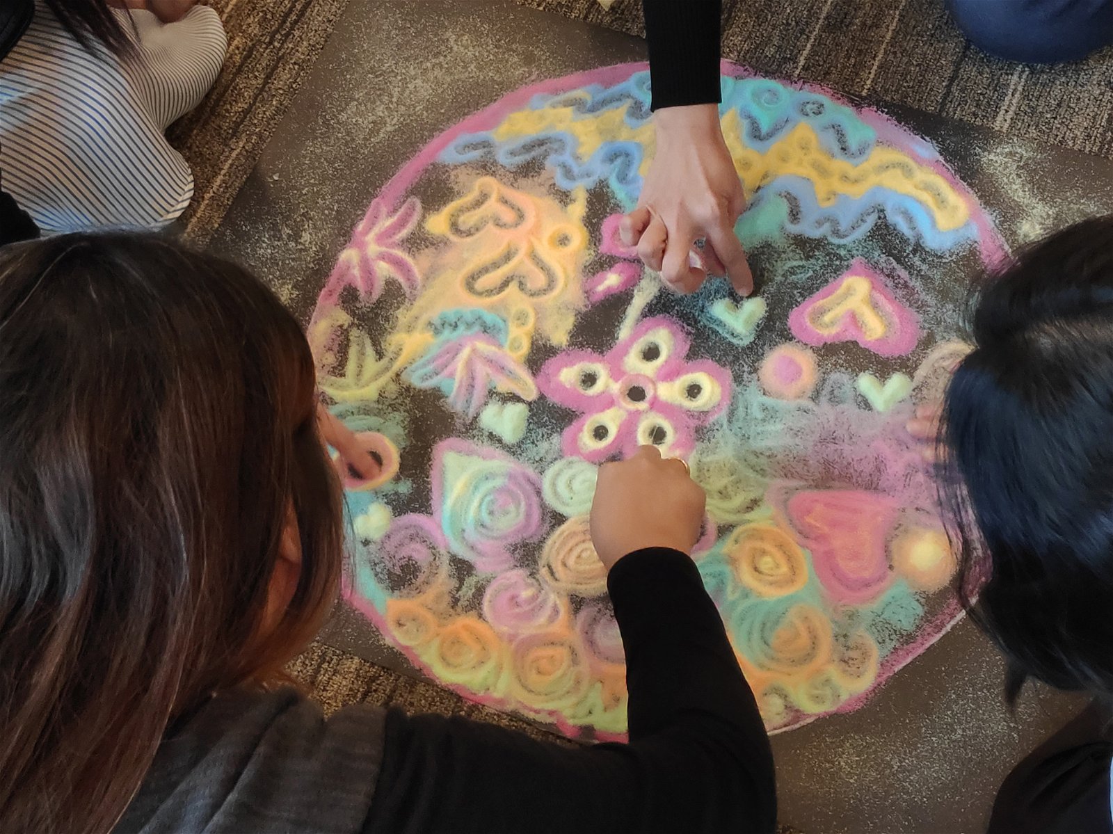 在“沙游曼陀罗”的环境中，每个参与者都按照各自的创意用彩沙设计出独特的图案。