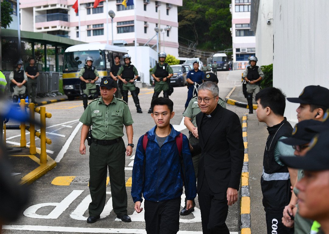 涉及台湾杀人案的疑犯陈同佳（蓝色风衣者）周三早上刑满出狱，他在圣公会教省秘书长管浩鸣护送下步离香港壁屋监狱。