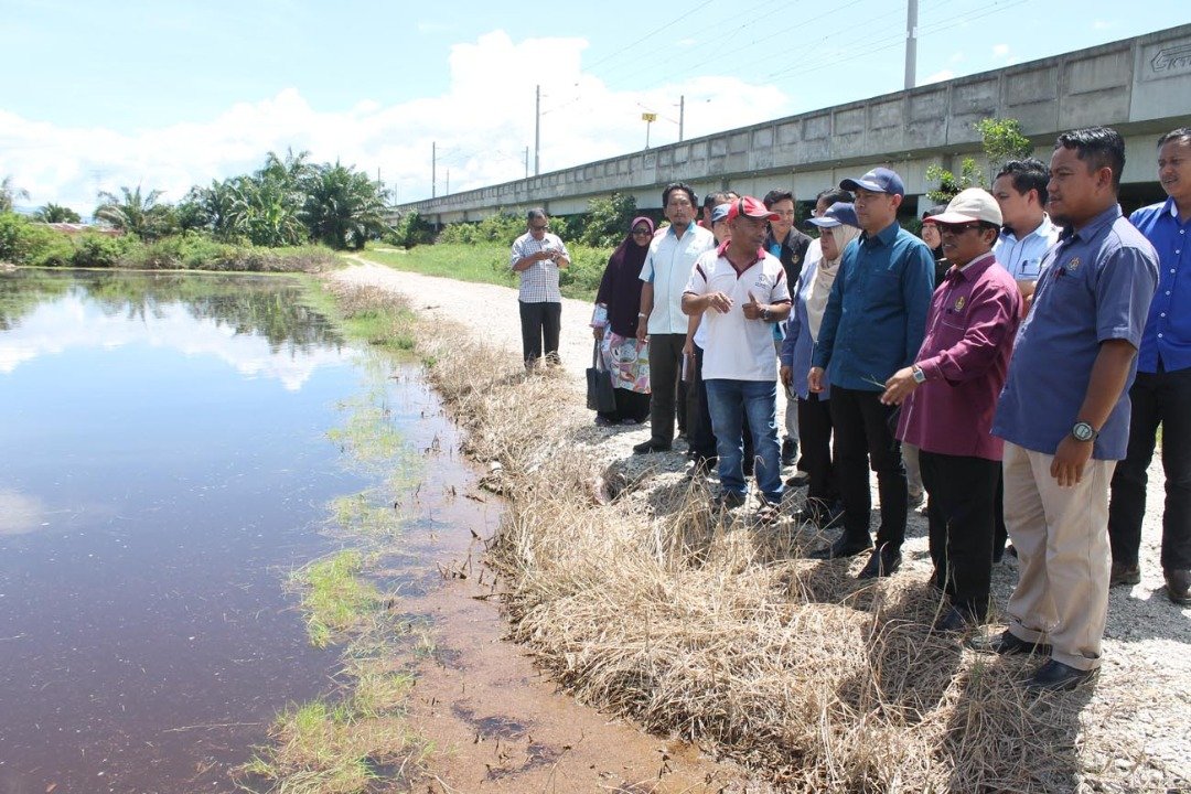 阿都尤努斯（右3）巡察峇眼色海甘榜马登默包遭雨水淹没的稻田，并慰问当地农民。