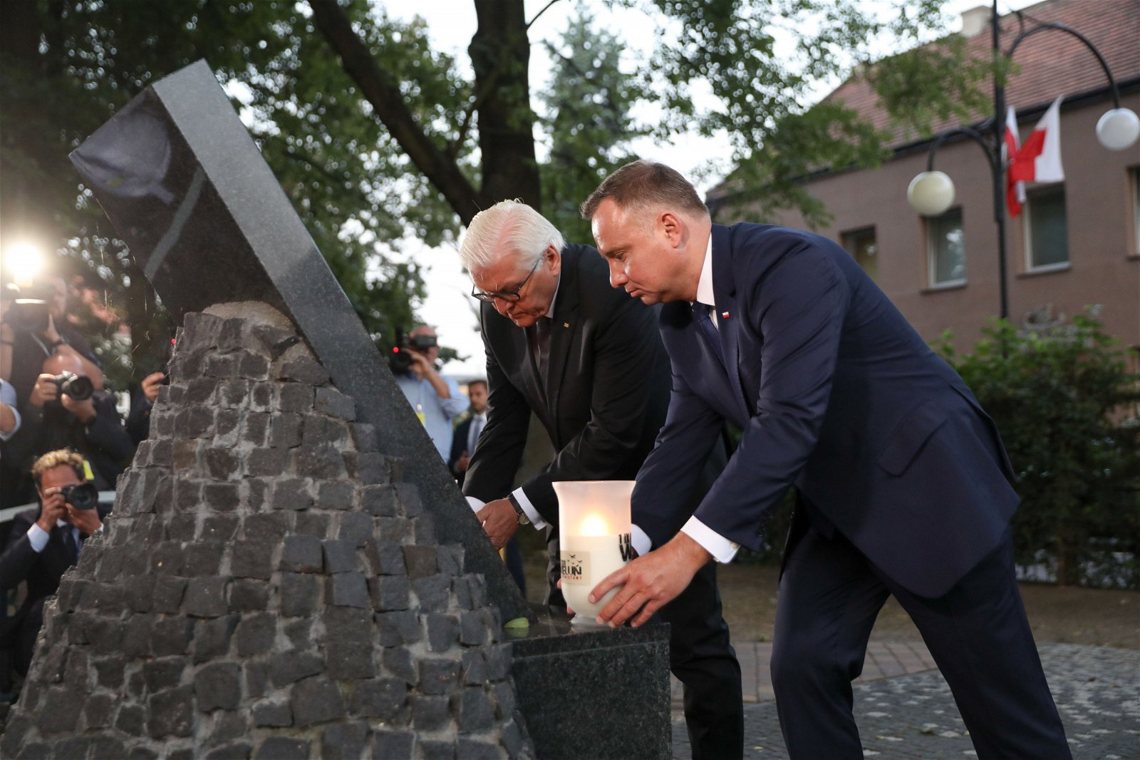 二战80周年纪念活动期间，德国总统施泰因迈尔（左）与波兰总统杜达在波兰小镇维隆的一座纪念碑前，一同点燃蜡烛。施泰因迈尔表示，希望得到波兰的宽恕，并强调德国会一定会铭记过去的侵略史。