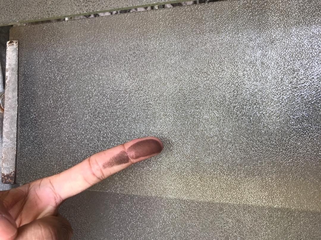 廖政光尝试以手指抹窗，沾满灰尘。