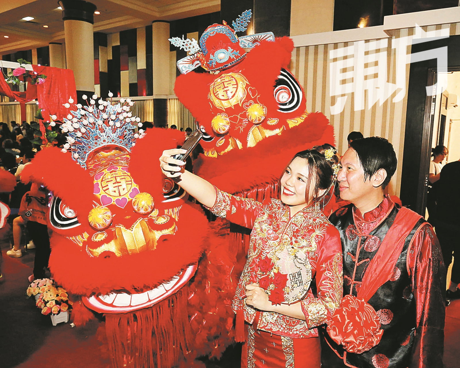 邢惠宝（左）和林凯聪身著传统龙凤褂，两人开心地与龙凤狮合照。（摄影：刘维杰）
