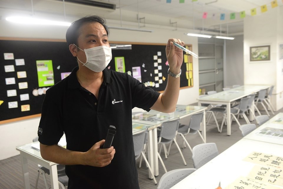邓振胜使用日本进口仪器，检测恒毅中学宏愿楼各角落的微生物指数。