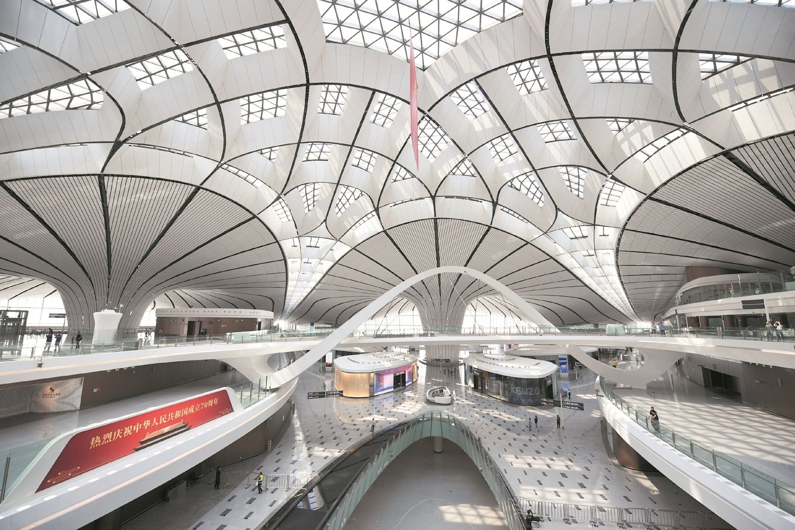 北京大兴国际机场拥有全球首座高铁地下穿行的机场航站楼、全球首座双层出发双层到达的航站楼。这是机场内部景象，只见其穹顶有著自然采光设计，整体简约又不失大气。