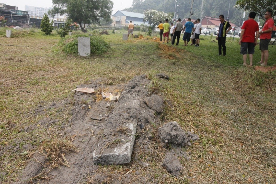 洪山宫义山的3个墓碑被厂巴撞断成两截。