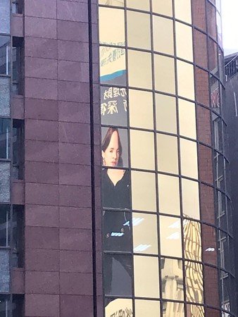 依林广告照反射在大楼玻璃，整个人变形。（图取自面子书／蔡依林）