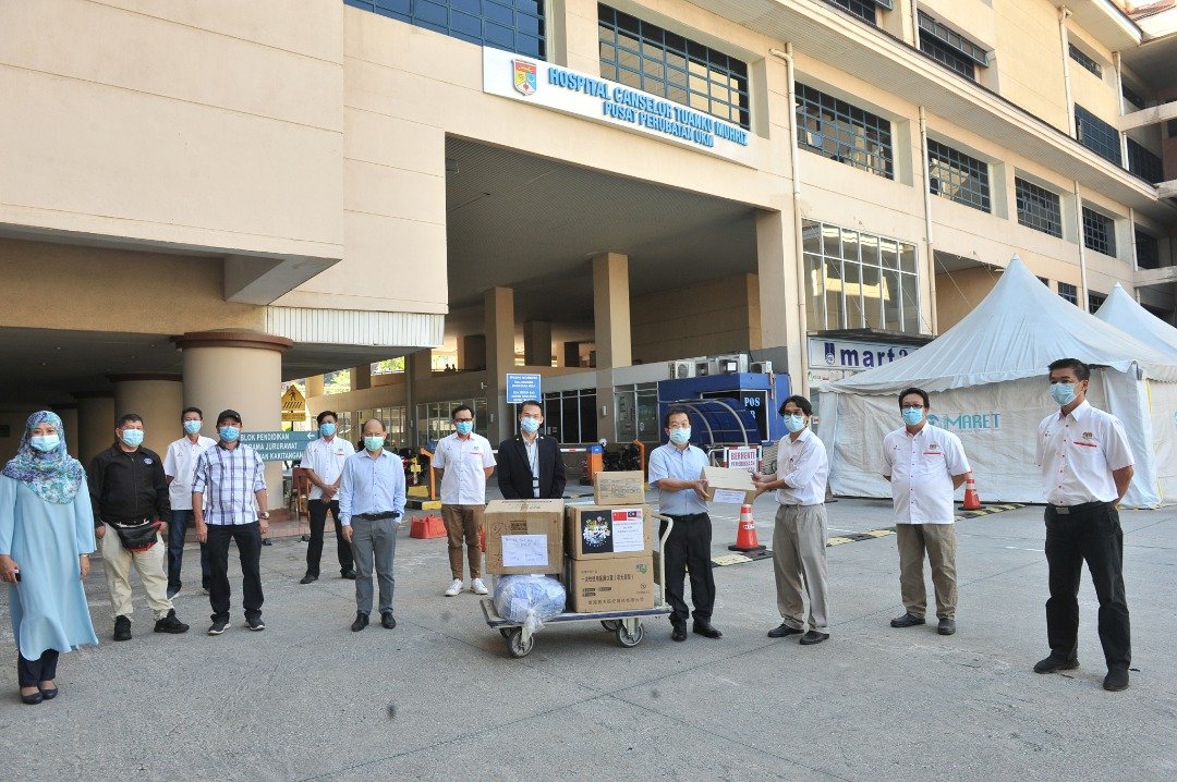 陈国伟(右3)收集国内外的善心人士捐赠的医疗物资给予国大医院，并由该院副院长哈林(右2)接领。