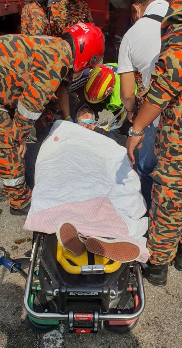 巫裔学员在包扎好伤口后抬上担架，送上救伤车送往医院救治。